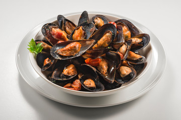 Bowl with cooked and open mussels