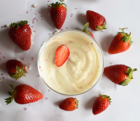 A cup of vanilla pudding with strawberries.Vanilla pudding closeup.