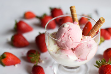 A cup of ice cream with strawberries and rolled wafers. ice cream closeup.