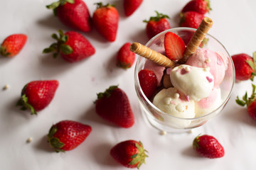A cup of ice cream with strawberries and rolled wafers. ice cream closeup.