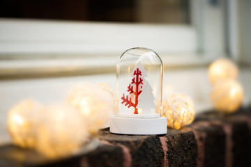 Christmas snow globe with trees and lights on a window, brick wall. Copy space