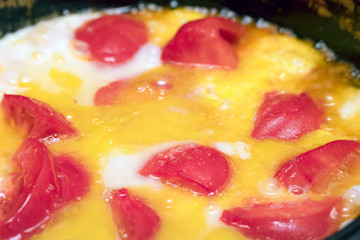 Fried eggs with tomatoes in pan