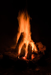 Campfire ablaze with stone circle and black background - 231739071