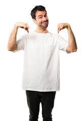 Young man with white shirt pointing down with fingers on isolated white background