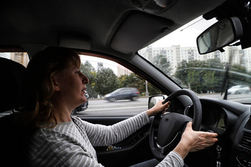 Middle aged woman driving a car in the city