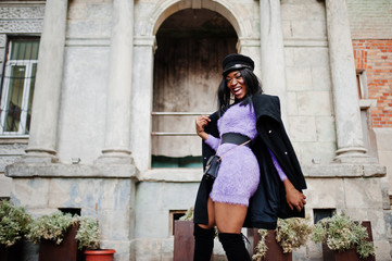 Fototapeta na wymiar African american woman at violet dress and cap posed outdoor.