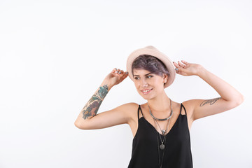 Trendy young woman with tattoos on white background. Space for text