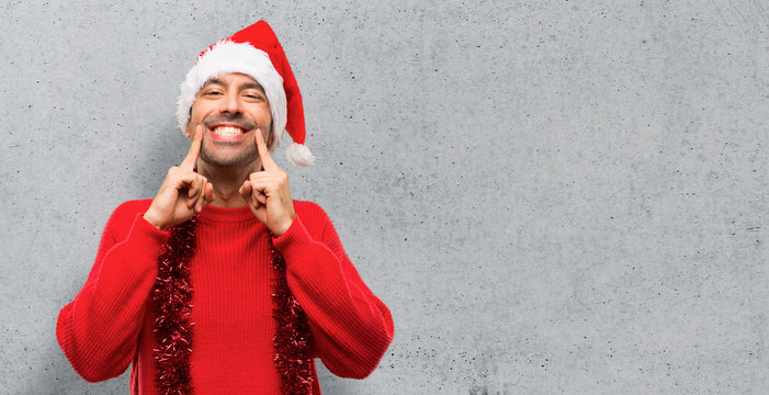 Man with red clothes celebrating the Christmas holidays smiling with a happy and pleasant expression on textured background