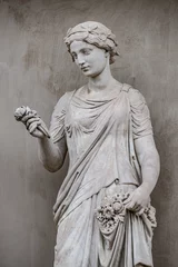 Poster Historic monument Ancient statue of sensual Greek renaissance era woman with a flower, Potsdam, Germany, details, closeup