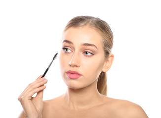 Portrait of young woman with beautiful natural eyelashes holding brush on white background