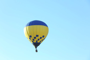 Colorful hot air balloon flying in blue sky. Space for text