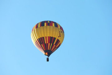 Colorful hot air balloon flying in blue sky. Space for text