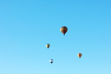Colorful hot air balloons flying in blue sky. Space for text