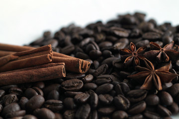 Obraz na płótnie Canvas Coffee beans and cinnamon sticks on white background.