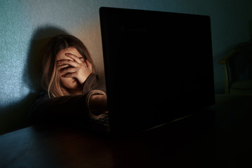 Teenager girl suffering internet cyber bullying scared and depressed cyberbullying. Image of...
