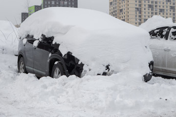 Cars under the snow. Snowfall in the city
