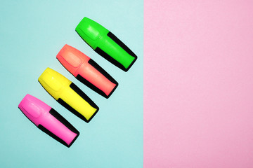 Multicolor felt tip pens on pastel pink and pastel blue background. Colorful markers