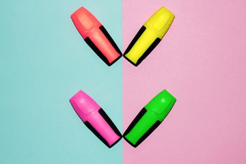 Multicolor felt tip pens on pastel pink and pastel blue background. Colorful markers