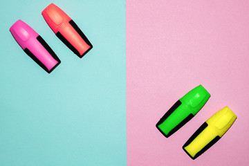 Multicolor felt tip pens on pastel pink and pastel blue background. Colorful markers