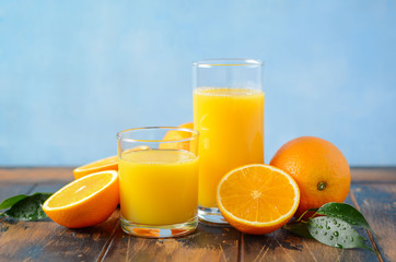 Naklejka na ściany i meble Fresh orange juice in a glasses on old wooden table, selective focus.