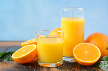 Naklejka na ściany i meble Fresh orange juice in a glasses on old wooden table, selective focus.