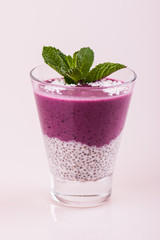 Berry smoothie. Purple pudding in a glass on a white background.