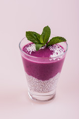 Berry smoothie. Purple pudding in a glass on a white background.