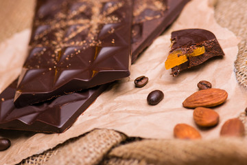 Black chocolate close-up on a light background. Coffee, chocolate on paper.