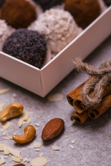 Candy in a white box close-up. Brown round candies, nuts, cinnamon
