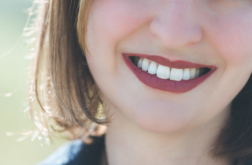 Beautiful girl with cherry red lips and white teeth is smiling