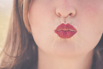 Cherry red lips of young girl are kissing