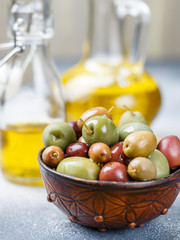 Mixed marinated olives (green, black and purple) in ceramic bowl  and olive oil