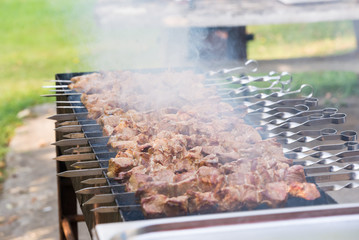 cooking meat on the coals in a large grill in an outdoor restaurant