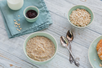 Fototapeta na wymiar Oatmeal porridge bowl on the white wooden background.