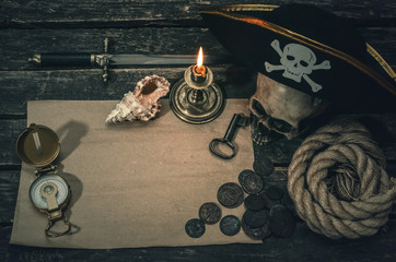 Pirate treasure map with copy space, pirate captain hat, compass, coins, human skull, mooring rope,...
