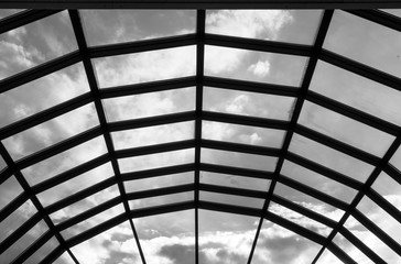 Modern glass roof with steel grid frames. Skylight rooftop window with symmetrical grid steel beams. Architectural detail and design on glass rooftop	