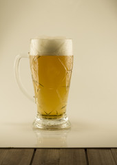 Filled with beer glass with white foam on a white isolated background