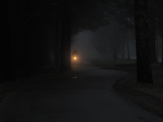 Cyclist riding bicycle on a one foggy evening