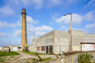 abandoned industrial building with a high brick chimney