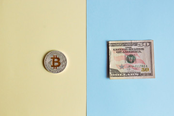 Bitcoins and dollars on a pastel background, the concept of confrontation between cryptocurrency and paper money