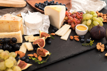 Cheese plate served with grapes, jam, figs