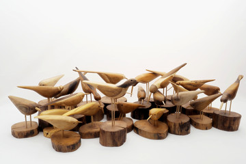 Sculptures of wooden birds on white background