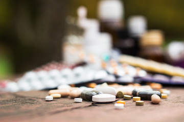 Medicines on wooden table, nature bokeh background