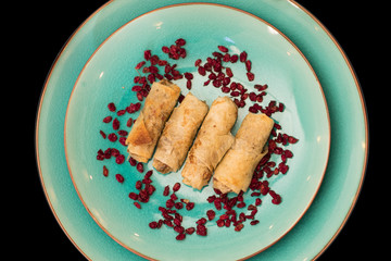 Delicious chicken and onion roll ups garnished with dried pomegranate seeds top view