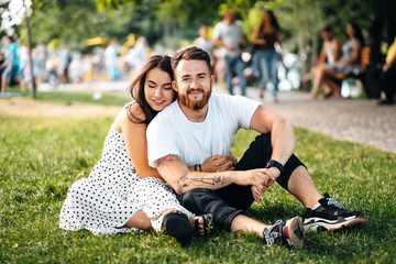 Naklejka premium Beautiful young girl hugging her handsome guy in the park.