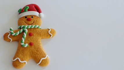 gingerbread man with red hat and buttons green and white scarf isolated on white background with writing space