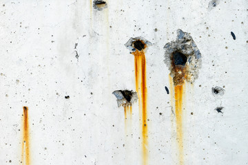 Rusty metal staining on white concrete wall surface