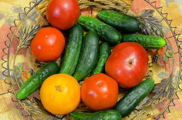 
Cucumbers and tomatoes are laid out on a metal decorative plate.