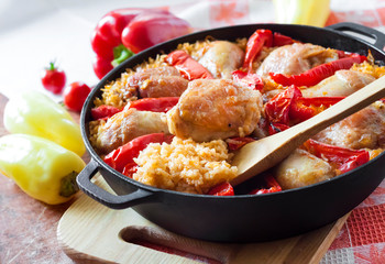 Chicken thighs and legs baked over a bed of rice and red bell pepper