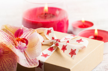 Orchids, craft gift box and lit candles
